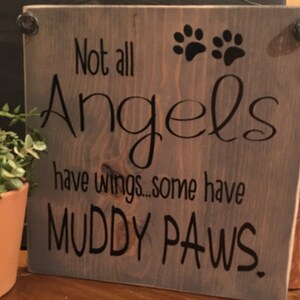 May include: A wooden sign with the text "Not all Angels have wings... some have MUDDY PAWS."  The sign has two black paw prints in the top right corner.