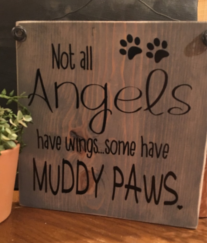 May include: A wooden sign with the text "Not all Angels have wings... some have MUDDY PAWS."  The sign has two black paw prints in the top right corner.