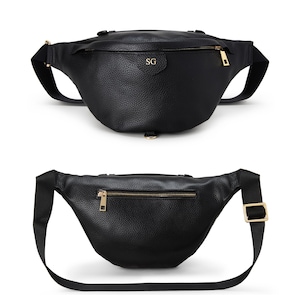 Peut inclure: Un sac banane noir &agrave; texture grain&eacute;e dot&eacute; de finitions dor&eacute;es, d'un compartiment principal zipp&eacute; avec les initiales SG grav&eacute;es sur le rabat avant, et d'une sangle en tissu noir r&eacute;glable avec une boucle dor&eacute;e pour une fermeture s&eacute;curis&eacute;e.