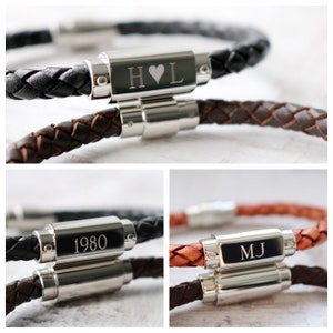 May include: Two leather bracelets with silver clasps. One bracelet has the initials "H♥L" engraved on the clasp. The other bracelet has the year "1980" engraved on the clasp.