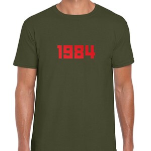 May include: A green t-shirt with the number 1984 printed in red on the front.