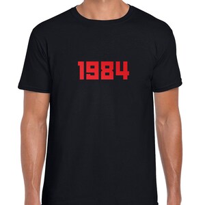 May include: A black t-shirt with the number 1984 printed in red on the front.