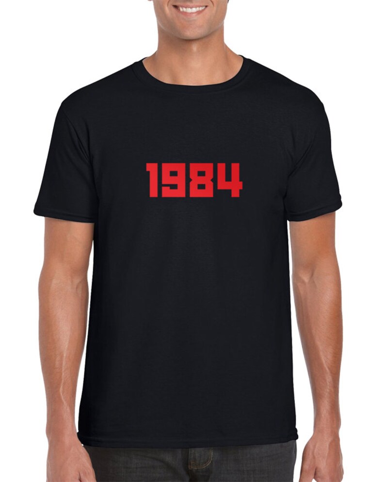 May include: A black t-shirt with the number 1984 printed in red on the front.