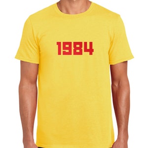 May include: Yellow short-sleeved t-shirt with the number 1984 printed in red on the front.
