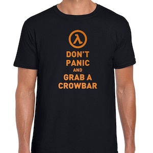 Könnte beinhalten: Schwarzes T-Shirt mit einer orangefarbenen Grafik des Half-Life-Logos und dem Text "Don't Panic and Grab a Crowbar".
