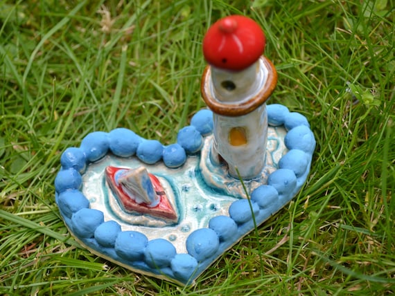 Mini ceramic heart boat in the sea with lighthouse