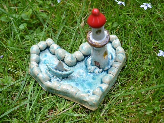 Mini ceramic heart boat in the sea with lighthouse