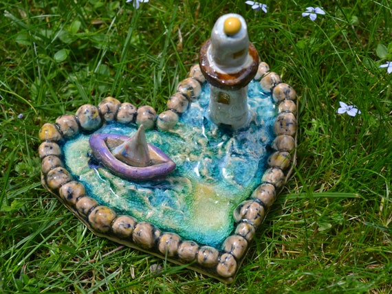 Mini ceramic heart boat in the sea with lighthouse