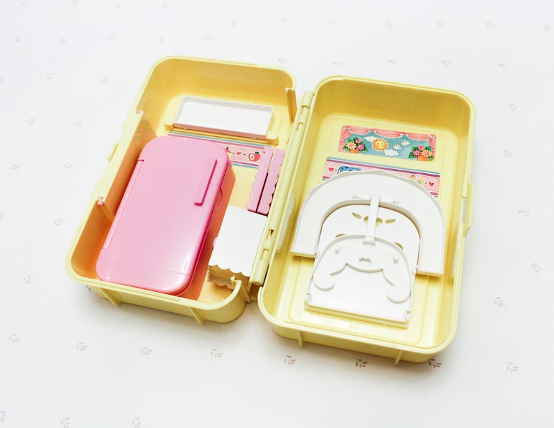 May include: A yellow plastic carrying case with a pink refrigerator, white chairs, and a white bed inside. The case is open and the items are visible.