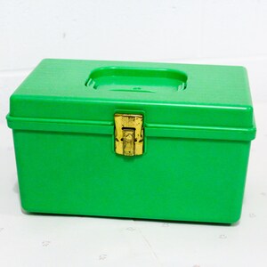 Puede incluir: Una caja de almacenamiento de pl&aacute;stico verde brillante con un cierre dorado. La caja tiene una tapa con bisagras y es ideal para organizar art&iacute;culos peque&ntilde;os.