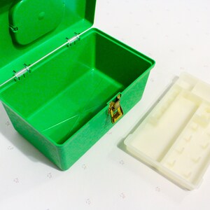 Puede incluir: Una caja de almacenamiento de pl&aacute;stico verde con un inserto de pl&aacute;stico blanco. La caja tiene un cierre y una peque&ntilde;a manija en la tapa. El inserto tiene varios compartimentos.
