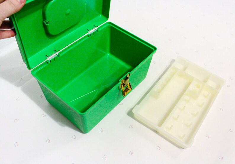 Puede incluir: Una caja de almacenamiento de pl&aacute;stico verde con un inserto de pl&aacute;stico blanco. La caja tiene un cierre y una peque&ntilde;a manija en la tapa. El inserto tiene varios compartimentos.