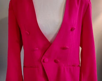 May include: A bright pink blazer with a deep V-neck and double breasted closure. The blazer has long sleeves and two pockets.