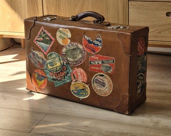Autentica valigia in pelle degli anni '30-'40 con etichette originali dell'hotel, rara reliquia da viaggio prebellica.