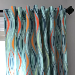 May include: Teal, orange, and blue patterned curtains with a geometric design. The curtains are hung on a white wall.