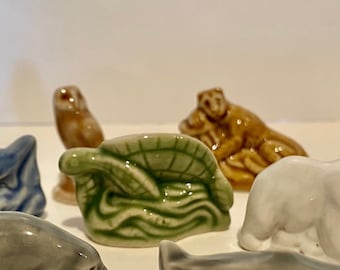 Può includere: Una collezione di dieci piccole figurine in ceramica che raffigurano vari animali, tra cui un gufo, una tartaruga, un orso polare, una balena e un pesce. Le figurine sono dipinte in vari colori, tra cui blu, verde, marrone e bianco.