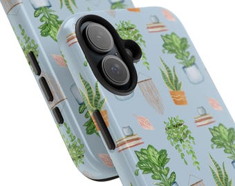 Puede incluir: Una funda para teléfono de color azul claro con un patrón de plantas en macetas y macramé colgante. La funda tiene un recorte para el objetivo de la cámara negro.