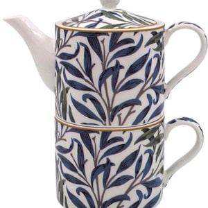 May include: A white ceramic teapot and teacup set with a blue and green leaf design. The teapot has a lid and spout, and the teacup has a handle. The set is designed for tea service.