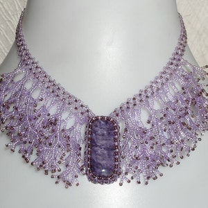 May include: A delicate purple beaded necklace with a large, rectangular amethyst gemstone pendant.