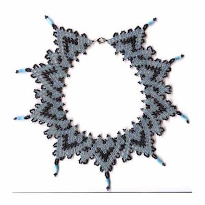 May include: A delicate necklace made of black and light blue beads, arranged in a geometric pattern. The necklace has a silver clasp and is approximately 18 inches long.