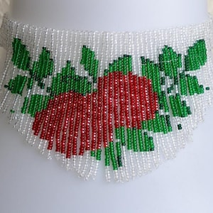 May include: A beaded choker necklace featuring a red and green design of two hearts with leaves. The necklace is made from small white, red, and green beads.