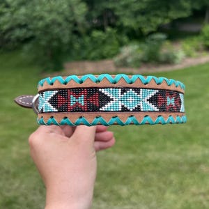 Leather dog collar with teal, white, and burgundy navajo beaded inlay design, a rawhide wrapped edge