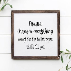 May include: A framed sign with a white background and black text that reads "Prayer changes everything except for the toilet paper. That's all you."