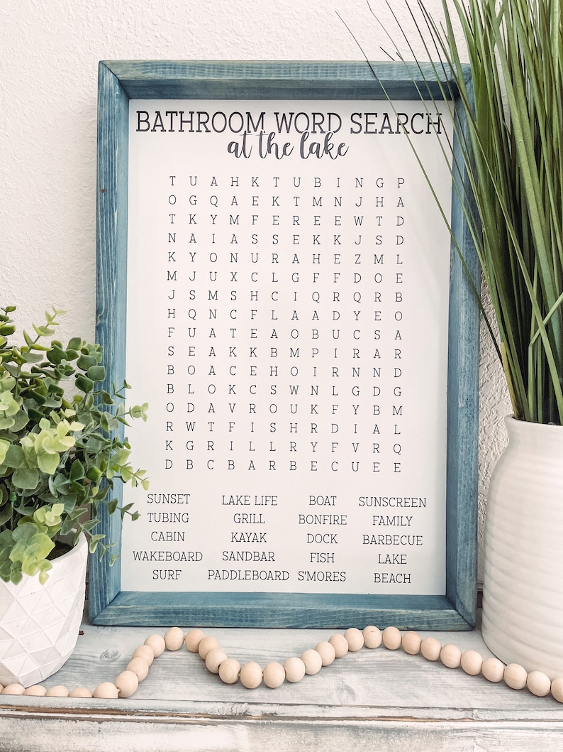 May include: A blue framed word search puzzle with the title "Bathroom Word Search at the Lake". The puzzle features a grid of letters with words related to the lake and bathroom. The words are listed below the puzzle.