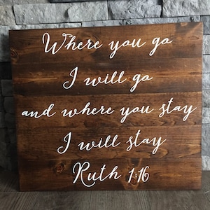 May include: A wooden sign with the text "Where you go I will go and where you stay I will stay Ruth 1:16" in white lettering.