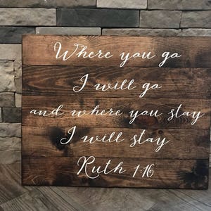 May include: A wooden sign with the text "Where you go I will go and where you stay I will stay Ruth 1:16" in white cursive lettering.