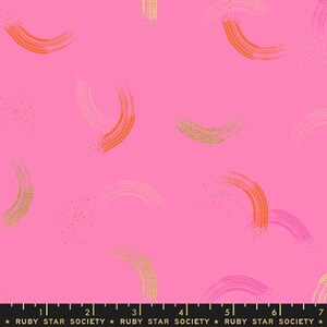 May include: Pink fabric with a repeating pattern of gold and orange brushstrokes in the shape of arcs. The fabric has a subtle sparkle.