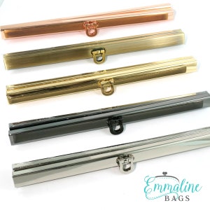 May include: Five different metal purse frames, each with a different finish: rose gold, gold, black, silver, and nickel. The frames are all the same size and shape, and they each have a small loop at the top for attaching a strap.