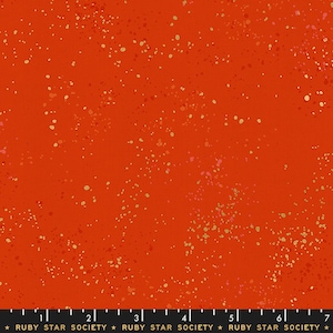 May include: Red fabric with a speckled pattern of gold and orange dots. The fabric is from Ruby Star Society.