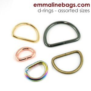 May include: Assortment of D-rings in various sizes and finishes, including gold, silver, rose gold, and rainbow.