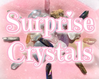 May include: A pink fuzzy surface with the text "Surprise Crystals" in white letters. A variety of crystals are scattered on the surface, including clear, pink, purple, and brown crystals.