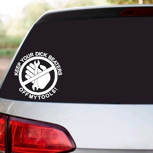 May include: White vinyl decal with the text "KEEP YOUR DICK BEATERS OFF MY TOOLS!" in a circular design. The design includes a hand holding a wrench, crossed out with a red line. The decal is affixed to the rear window of a car.