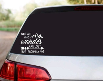 May include: White vinyl decal sticker for a car with the text "Not all who wander are lost [But I probably am]" with a mountain range and arrow graphic.