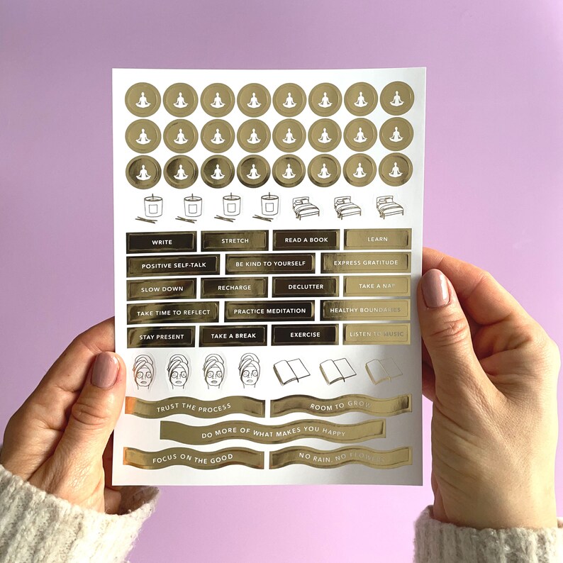 May include: A sheet of gold foil stickers with various self-care affirmations and illustrations. The stickers include phrases like "Trust the Process", "Do More of What Makes You Happy", and "Focus on the Good".