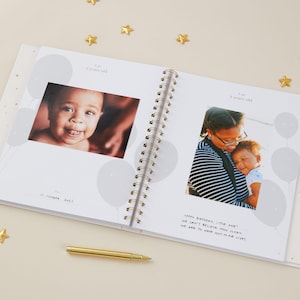 Aqua baby memory book with light blue cover and gold foiled details, designed as a milestone journal for recording memories from pregnancy through early childhood. With 114 guided pages, it helps parents capture important milestones and everyday moments with ease, while leaving room for photographs and notes. Gender-neutral and inclusive, this baby record book comes in a matching foiled presentation box, making it a beautiful baby shower keepsake.