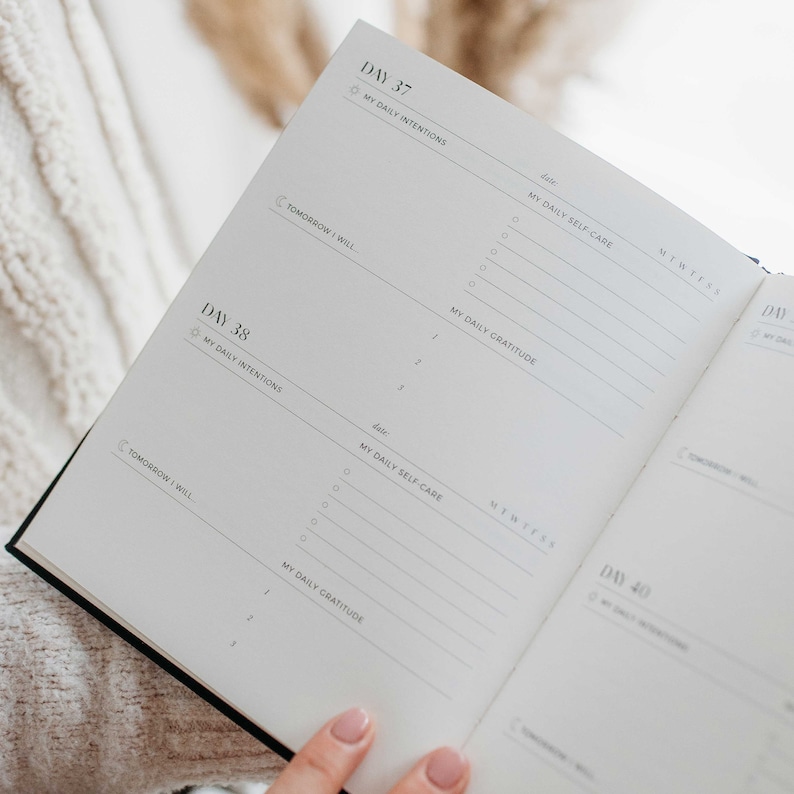 Op de afbeelding: Een witte planner met zwarte tekst, getiteld "Dag 37" en "Dag 38". De planner heeft secties voor "Mijn dagelijkse intenties", "Mijn dagelijkse zelfzorg" en "Mijn dagelijkse dankbaarheid".