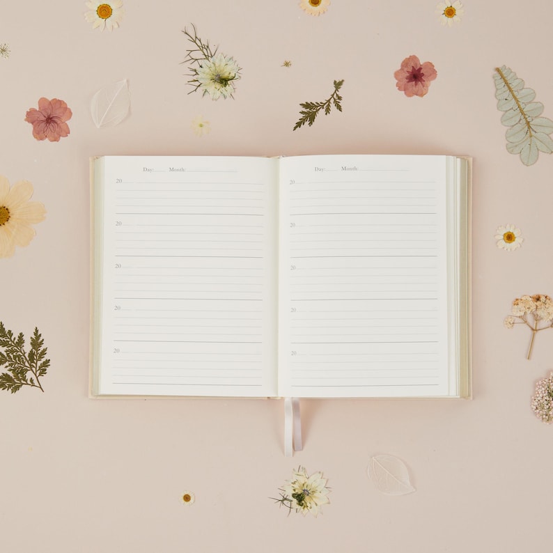 Interior pages of the wildflower mum journal showing five entry spaces per page, designed to record the same calendar day over five consecutive years.