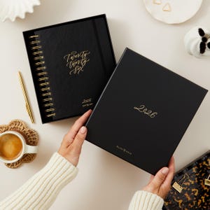 Black vegan leather 2026 daily planner, ring-bound diary with gold foil, elegant organiser for productivity and time management.