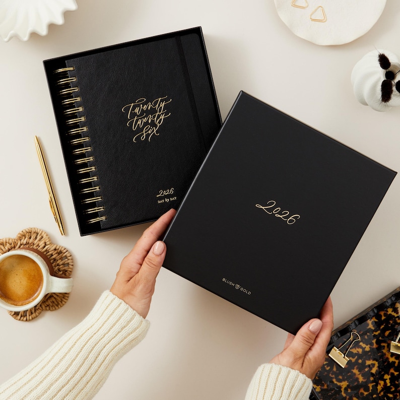 Black vegan leather 2026 daily planner, ring-bound diary with gold foil, elegant organiser for productivity and time management.