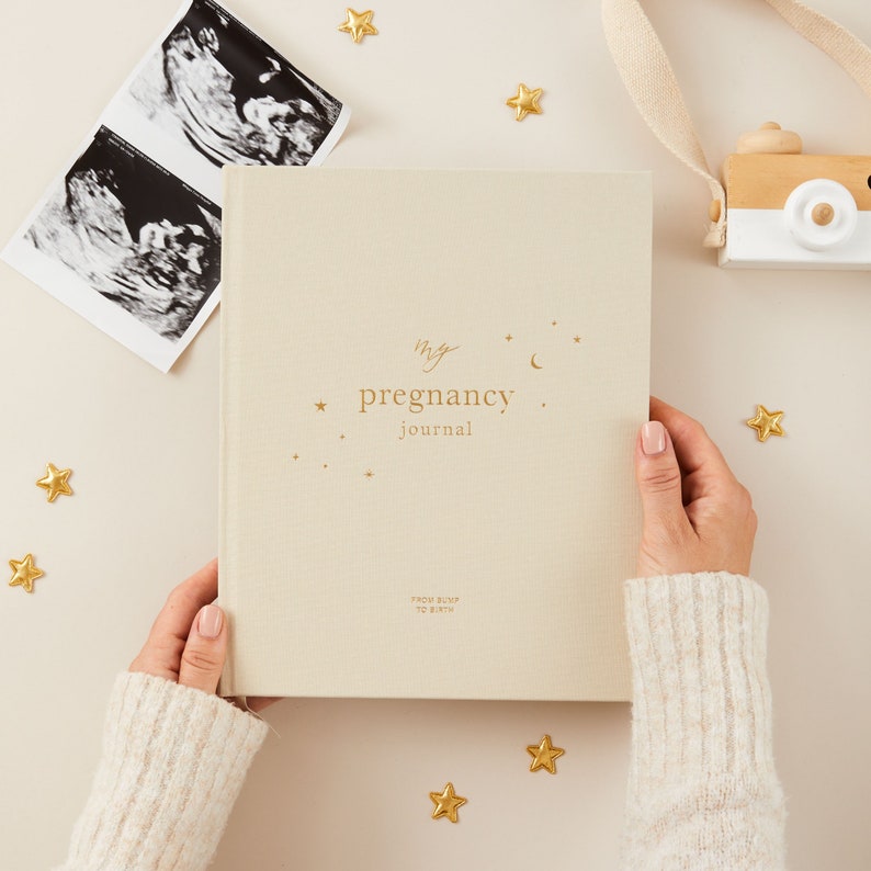 Elegant ivory gender-neutral pregnancy journal with minimalist design, perfect for all expecting parents to document their journey.