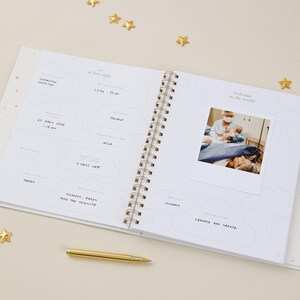 Light blue aqua baby memory book with cloth cover and elegant gold foil details, designed as a keepsake for recording milestones from birth to age 5. Inside are 114 guided pages with prompts for pregnancy, first words, first steps, birthdays, and family celebrations. The gender-neutral layout makes it suitable for baby girls and boys. Supplied in a matching foiled presentation box, this baby record book is a timeless keepsake and thoughtful newborn gift.