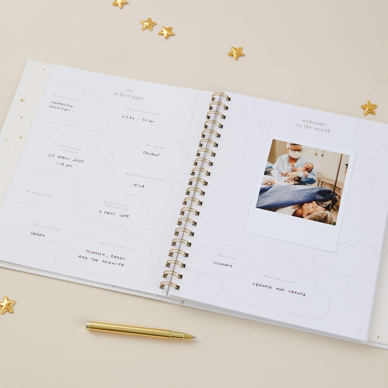 Light blue aqua baby memory book with cloth cover and elegant gold foil details, designed as a keepsake for recording milestones from birth to age 5. Inside are 114 guided pages with prompts for pregnancy, first words, first steps, birthdays, and family celebrations. The gender-neutral layout makes it suitable for baby girls and boys. Supplied in a matching foiled presentation box, this baby record book is a timeless keepsake and thoughtful newborn gift.