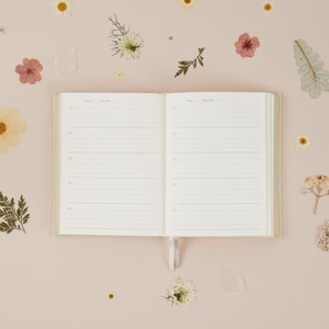 Motherhood memory book with ivory cloth cover and simple, elegant layout