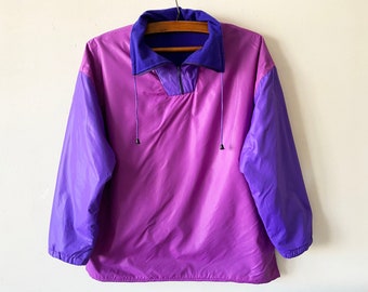 May include: A purple and blue windbreaker jacket with a half-zip closure and a drawstring hood.