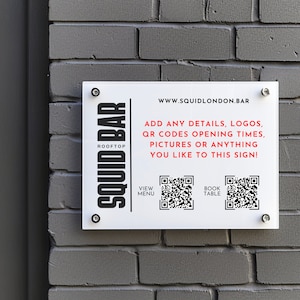 Può includere: Un cartello bianco con testo nero che recita "ROOFTOP SQUID BAR" e "WWW.SQUIDLONDON.BAR". Il cartello include anche il testo "ADD ANY DETAILS, LOGOS, QR CODES OPENING TIMES, PICTURES OR ANYTHING YOU LIKE TO THIS SIGN!" e due codici QR etichettati "VIEW MENU" e "BOOK TABLE".
