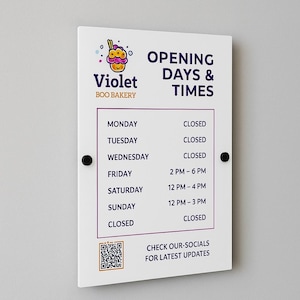 Peut inclure: Panneau blanc rectangulaire affichant "Violet Boo Bakery" et "Opening Days & Times" en violet. Le panneau indique les horaires d'ouverture de la boulangerie, dont 14h à 18h le vendredi et 12h à 16h le samedi. Un code QR est également présent.